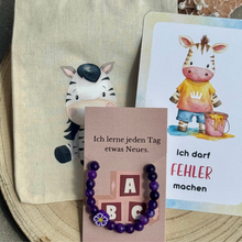 Laden Sie das Bild in den Galerie-Viewer, Mutmacher-Armband für Kinder aus Amethyst mit Blütenperle, Affirmationskarte, Kraftkarte und Stoffbeutel
